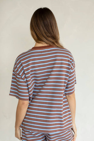 Person wearing a striped shirt and pants against a plain background