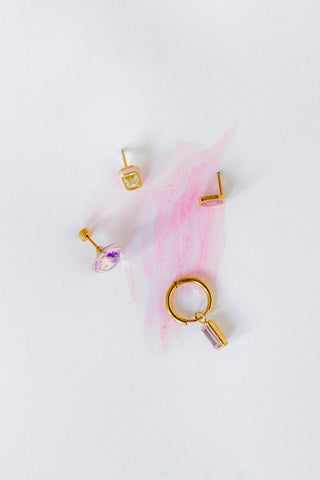 Gold jewelry pieces including earrings and a necklace on a white background