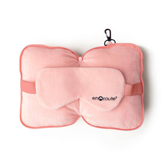 Pink travel pillow with matching eye mask on a white background, featuring 'enroute' branding.
