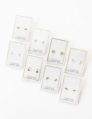 Set of gold earrings on LINNY CO branded cards against a white background