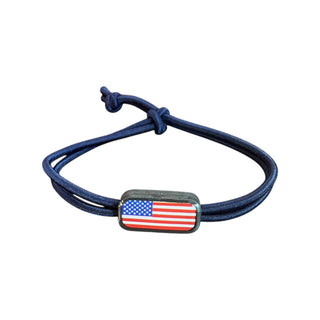 Navy blue bracelet with American flag charm on a white background