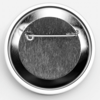 Close-up of the back of a round pin-back button, showing a metallic silver rim and a textured dark gray center with a pin fastener visible at the top.