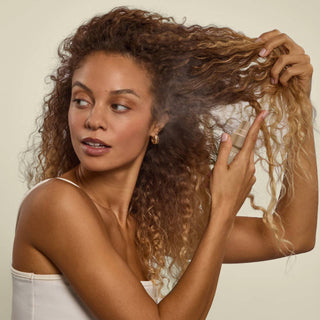 Model holding Kitsch Pistachio Latte Hair Perfume