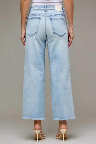 Light blue jeans worn by a person on a neutral background