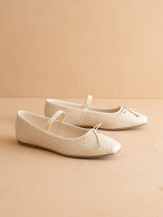 Pair of beige crocodile-patterned shoes on a beige background