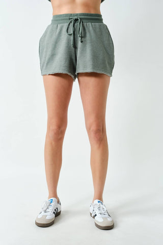 Person wearing green shorts on a plain background