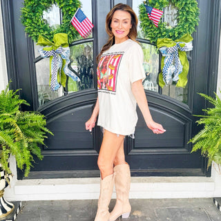 Woman standing in front of a decorated door with wreaths and American flags.