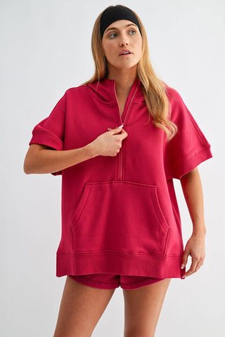 Woman wearing a red hoodie and shorts set on a white background