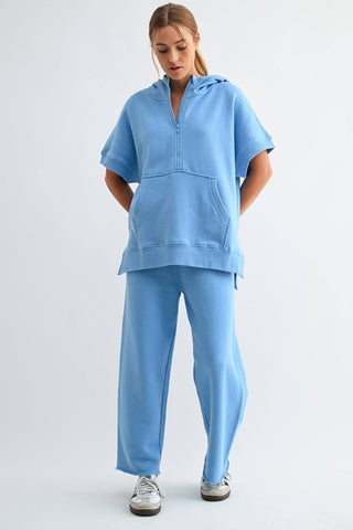 Person wearing a light blue tracksuit on a white background