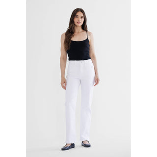 Woman wearing a black tank top and white pants on a white background