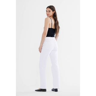 Woman wearing a black top and white pants on a white background