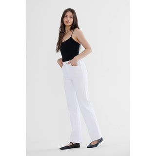 Woman wearing a black top and white pants on a white background