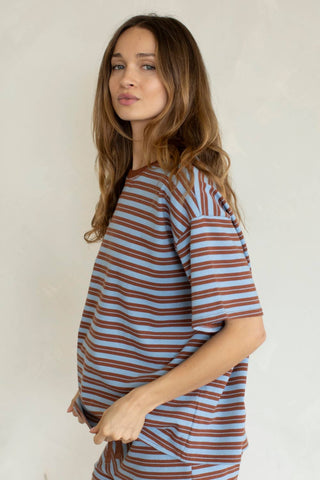 Woman wearing a striped shirt against a plain background