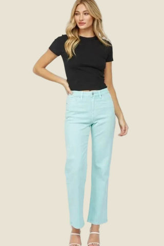 Woman wearing a black t-shirt and light blue jeans on a white background