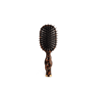 A paddle hairbrush with a glossy tortoiseshell handle and black bristles, centered on a plain white background.