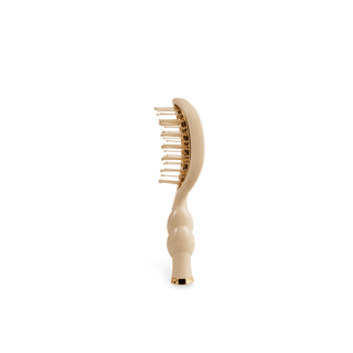 Beige hairbrush on a white background