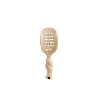 A single beige hairbrush with a wavy slotted head and a twisted handle, centered on a plain white background.