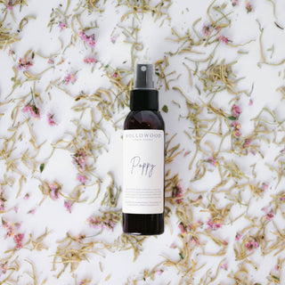 Spray bottle labeled 'Poppy' on a floral background