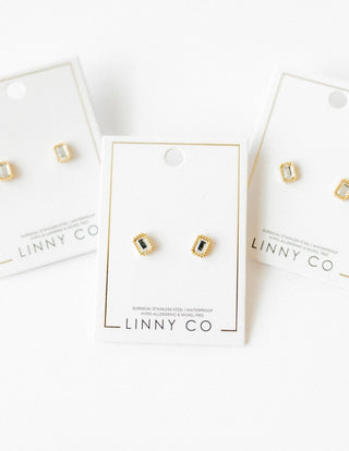 Gold and green gemstone earrings on LINNY CO branded cards against a white background