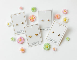 Set of earrings on LINNY CO cards with decorative flowers around