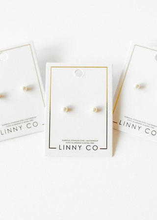 Pearl earrings on LINNY CO branded cards with a white background