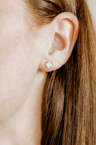 Close-up of an ear with a gold stud earring