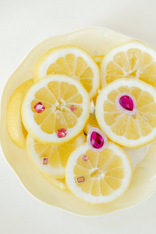 Lemon slices with pink gemstones on a white background