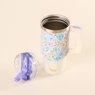 Floral-patterned tumbler with a purple lid on a beige background
