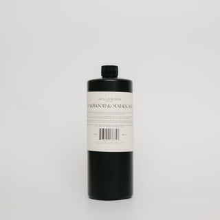 A tall black bottle with a white label reading 'HOLLOWWOOD TEAKWOOD & Mahogany' on a light gray background.