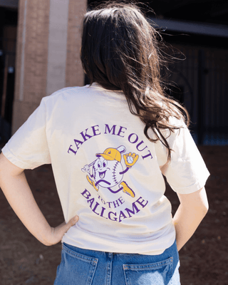 Person wearing a white t-shirt with 'Take Me Out to the Ballgame' text and graphic.