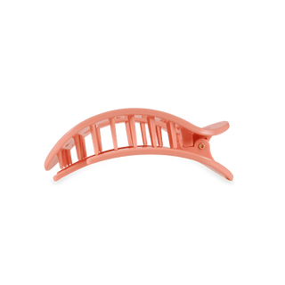 Coral-colored hair clip on a white background