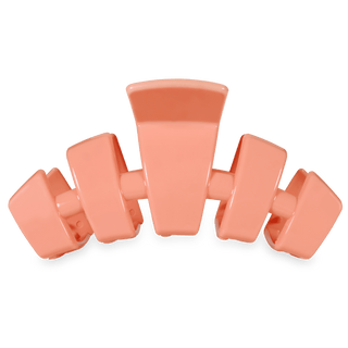 Coral-colored hair clip on a white background
