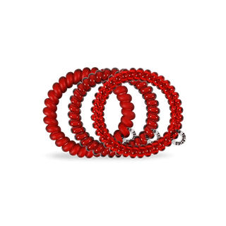 Red coil hair ties on a white background
