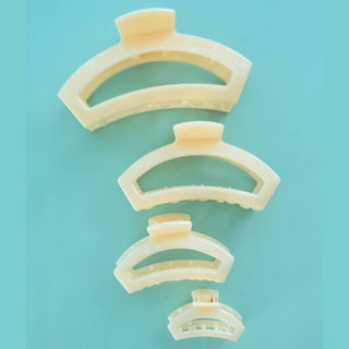 Set of beige hair clips arranged in a spiral on a light blue background