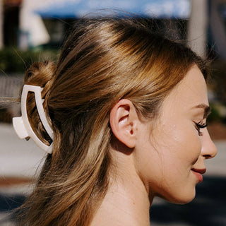 Woman with hair styled using a white hair clip outdoors