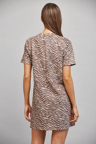 Person wearing a zebra print dress against a gray background