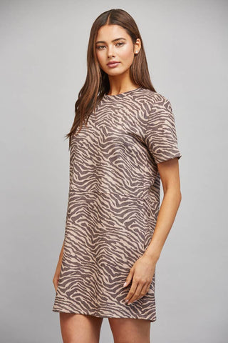 Woman wearing a zebra print dress against a gray background