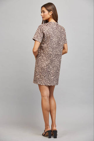 Woman wearing a patterned dress on a plain background