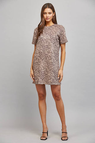 Woman wearing a patterned dress on a gray background