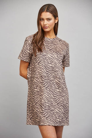Woman wearing a zebra print dress against a gray background