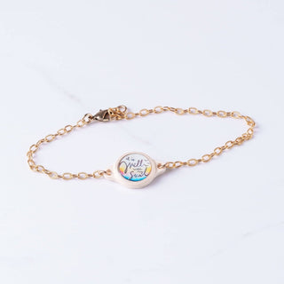 Gold bracelet with a heart-shaped charm on a white background