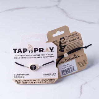 Bracelet with 'Tap to Pray' feature on packaging against a marble background
