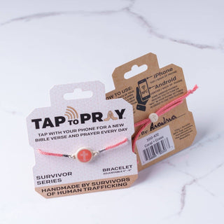 Pink bracelet with 'Tap to Pray' packaging on a white background
