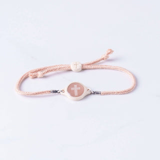 Bracelet with a cross charm on a light background