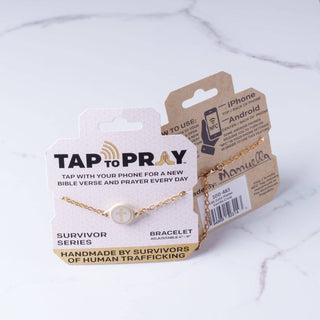 Gold bracelet on a 'Tap to Pray' packaging with a marble background