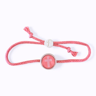 Pink bracelet with a silver clasp and cross charm on a white background