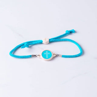 Turquoise bracelet with a cross charm on a light gray background