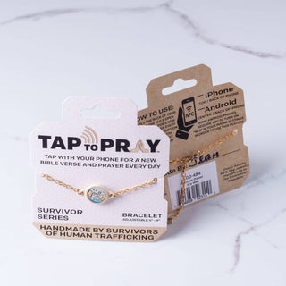 Gold bracelet on a 'Tap to Pray' packaging with instructions on a white background