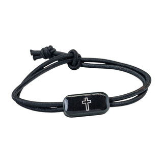 Black cord bracelet with a silver cross charm on a white background
