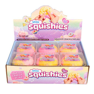 A retail display box of 'Wax Squishies' featuring six individually packaged pastel-colored squishy toys in pink, yellow, and orange, with a decorative header card.